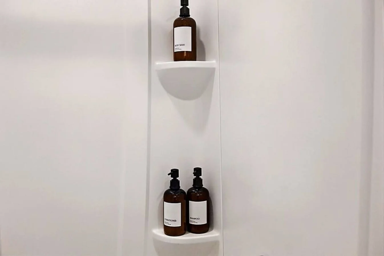 A spotless and modern bathroom offering premium bath essentials and a refreshing walk-in shower. Clean lines and minimalist shelving create a spa-like atmosphere that adds comfort and convenience to your stay.
