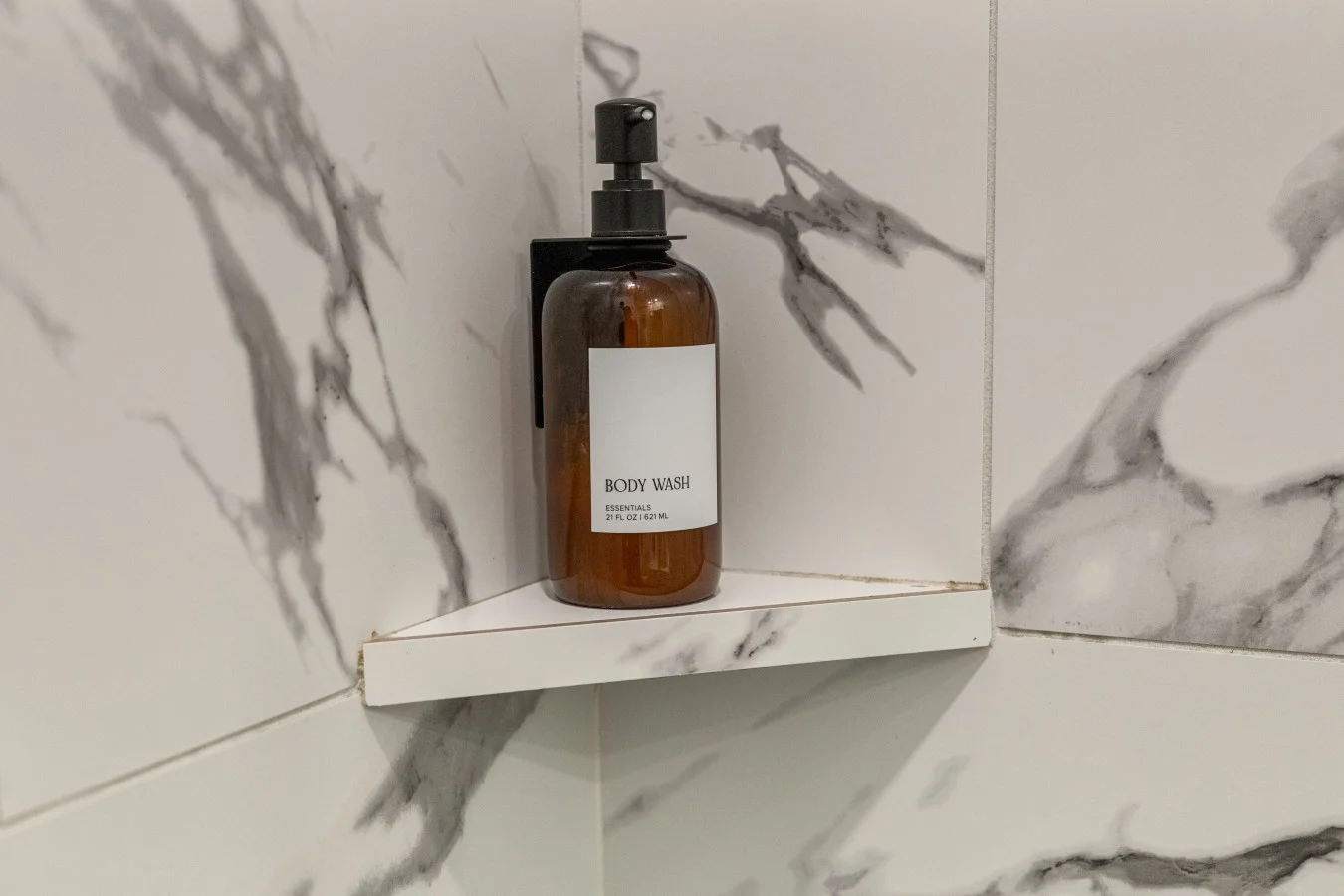 Modern convenience: Premium body wash provided in a stylish, marble-tiled shower.