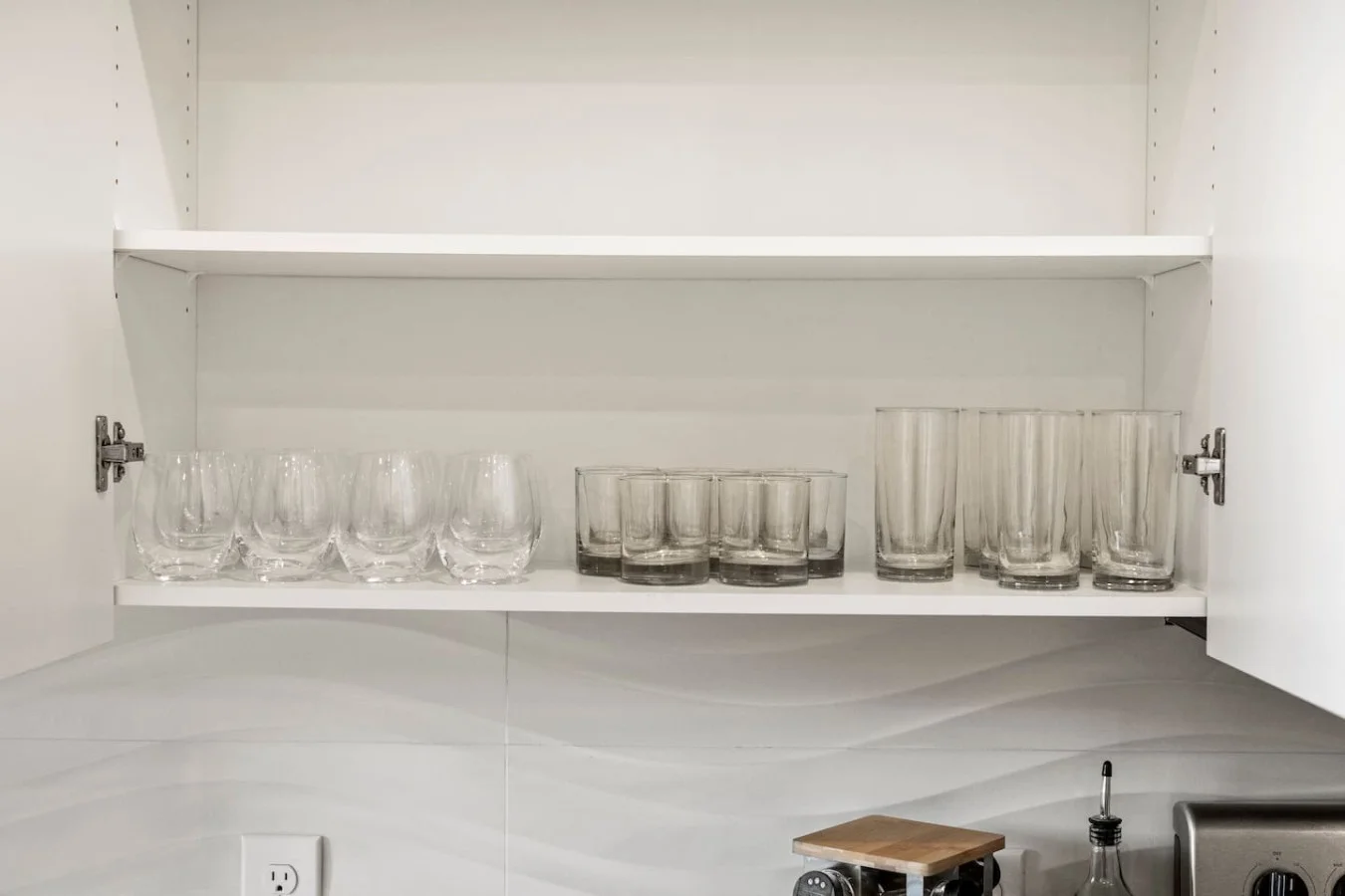 Kitchen cabinets stocked with cooking wares, glassware and silverwares, ideal for mixing up your favorite meals and drinks during your stay.