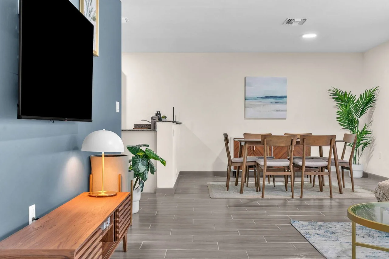 Spacious open-concept living and dining area featuring a vibrant sofa, modern furnishings, and a stylish entertainment setup—ideal for gatherings and relaxation.