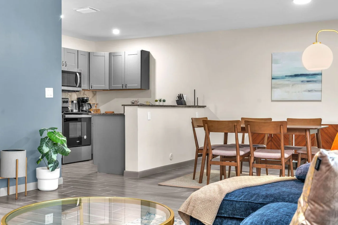 Spacious open-concept living and dining area featuring a vibrant sofa, modern furnishings, and a stylish entertainment setup—ideal for gatherings and relaxation.