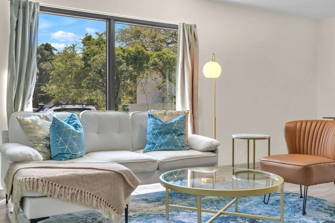 Minimalist yet inviting living room accented by greenery and a clean, uncluttered aesthetic.