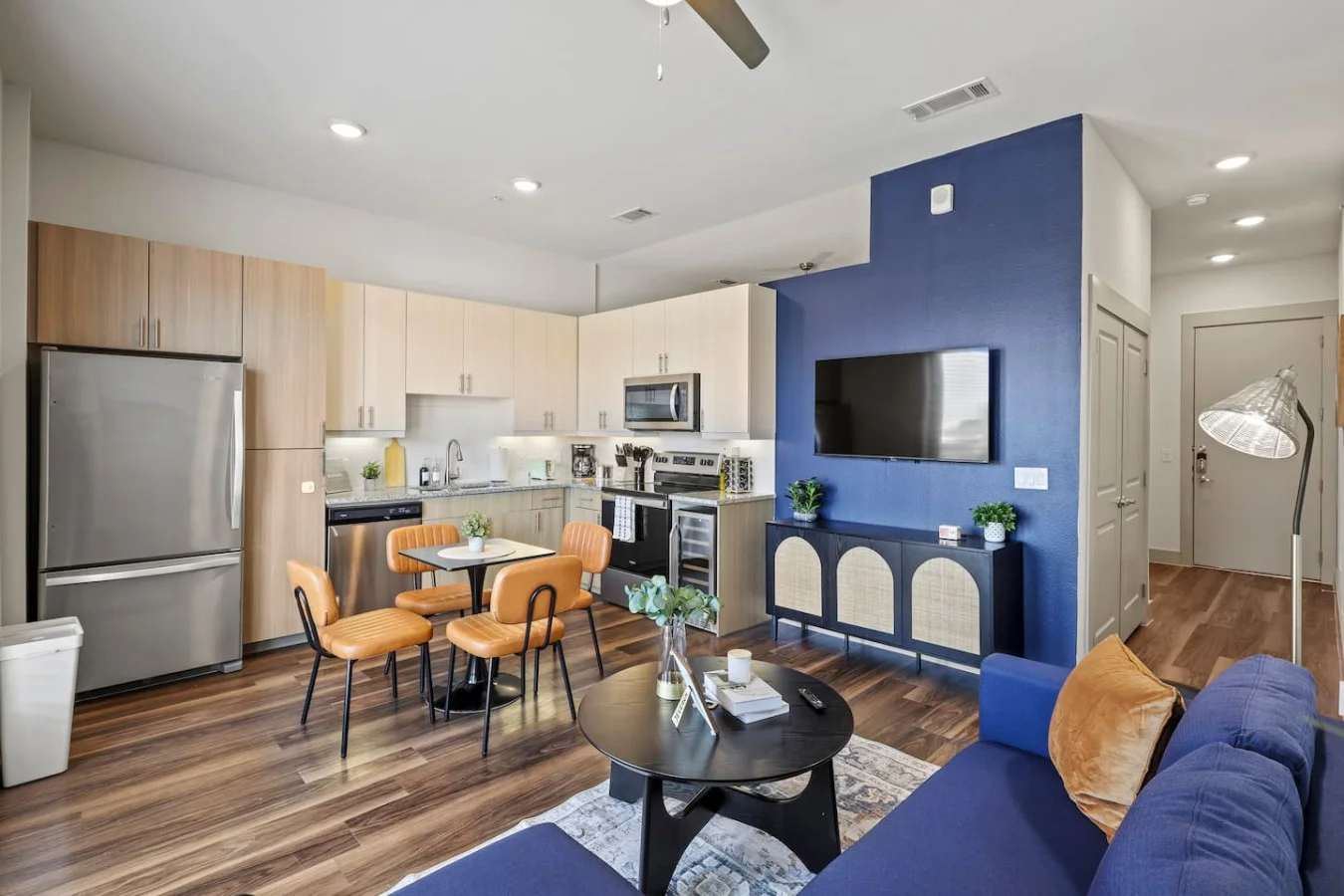 Spacious open-concept living and dining area featuring a vibrant sofa, modern furnishings, and a stylish entertainment setup—ideal for gatherings and relaxation.