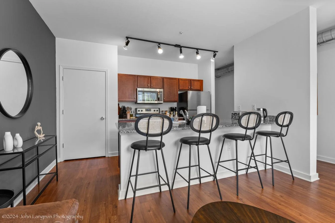 You imagine yourself mixing a cocktail at the stylish home bar, surrounded by a space that’s perfect for socializing.