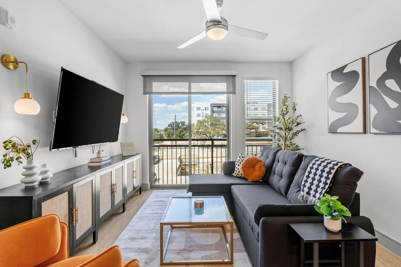 This bright living room combines plush seating, a large TV, and tasteful décor to create a welcoming space for comfort and entertainment.