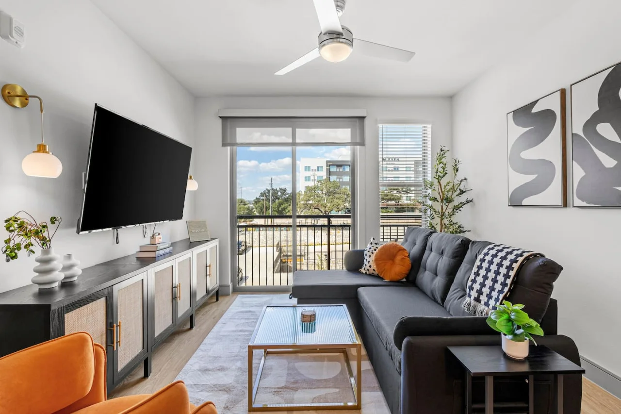 Bright and airy living room with plush seating, a large TV, and tasteful decor, creating the perfect space for relaxation and entertainment.