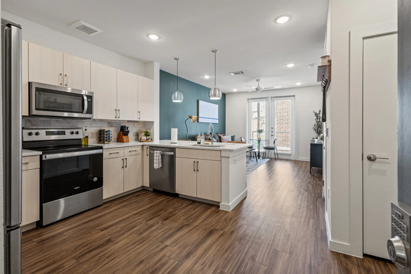 Bright, modern kitchen flows into spacious dining and living area with stylish finishes and plenty of natural light.
