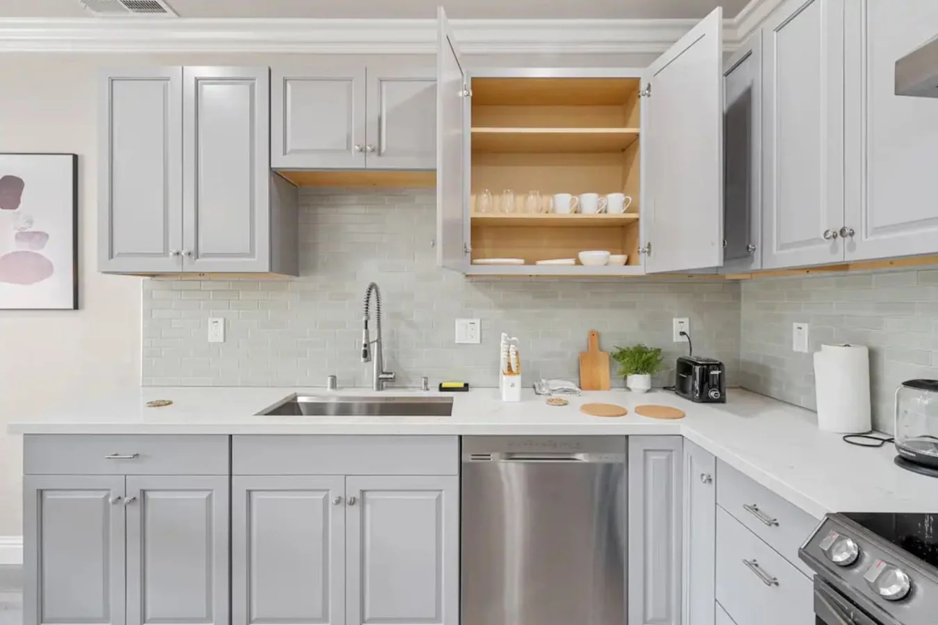 Kitchen cabinets stocked with cooking wares, glassware and silverwares, ideal for mixing up your favorite meals and drinks during your stay.