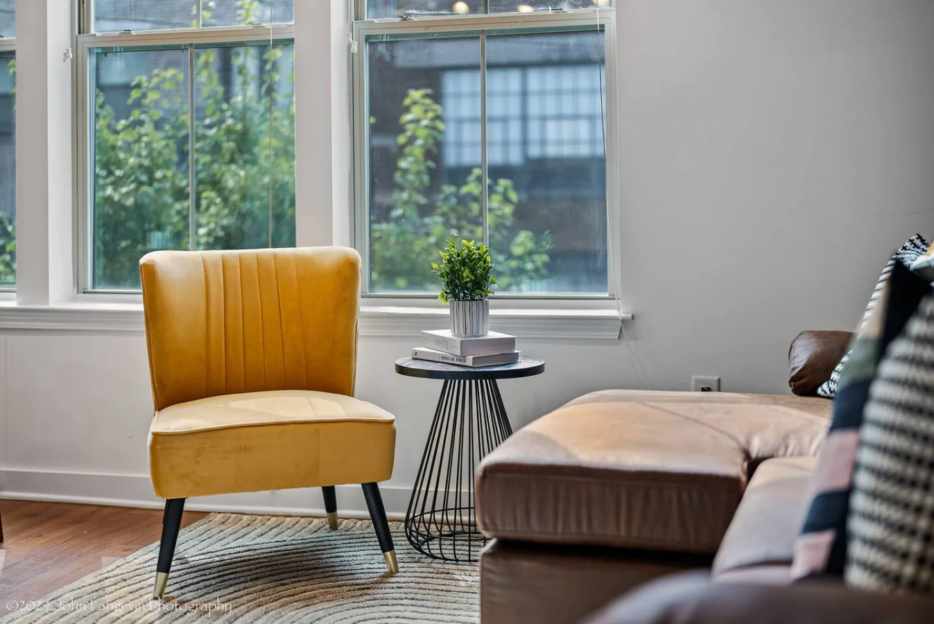 The living room’s plush seating beckons you to sink in and relax, surrounded by light and airy decor.