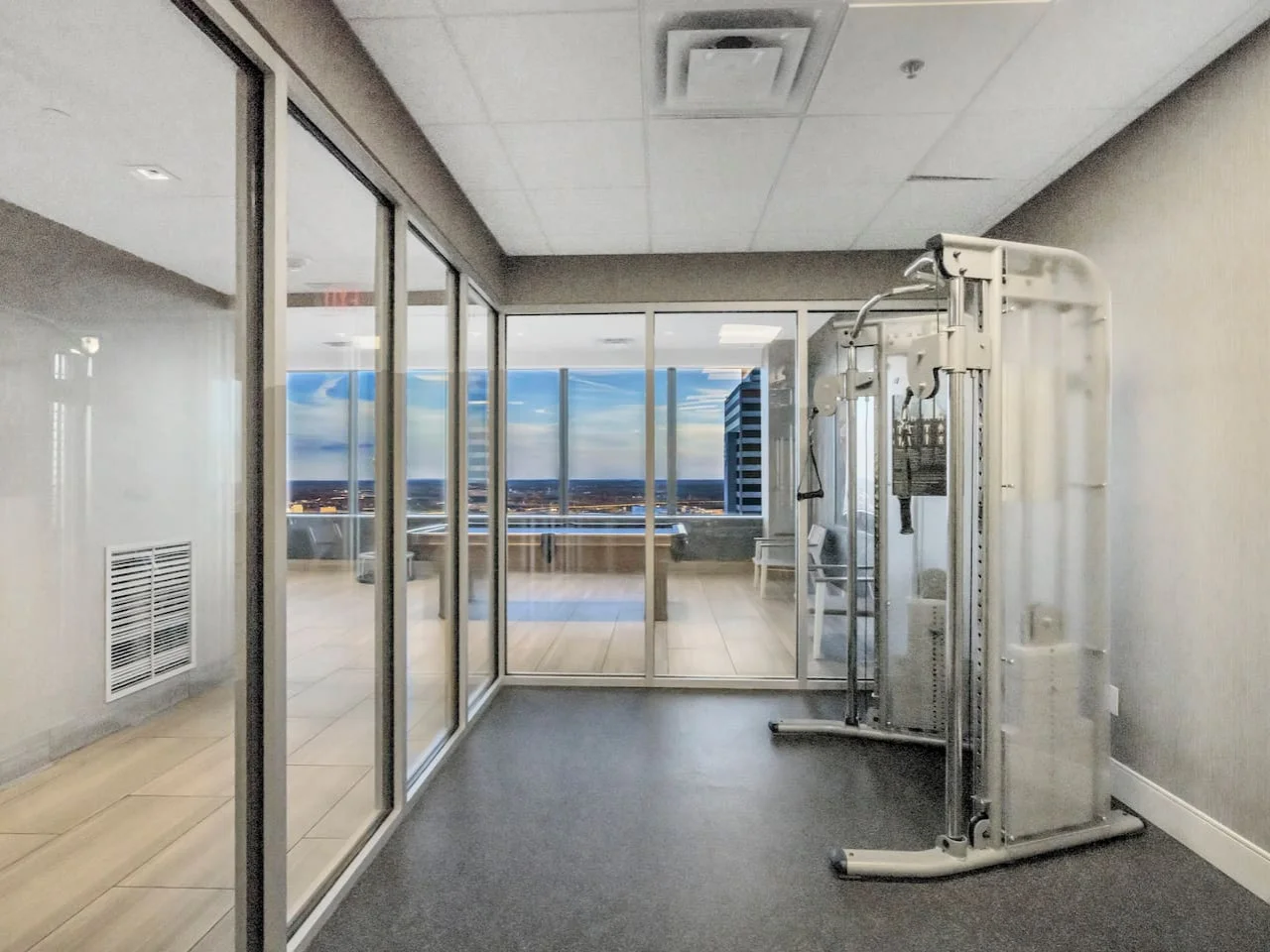 Spacious, well-lit gym equipped with a variety of cardio machines, free weights, and strength-training equipment.