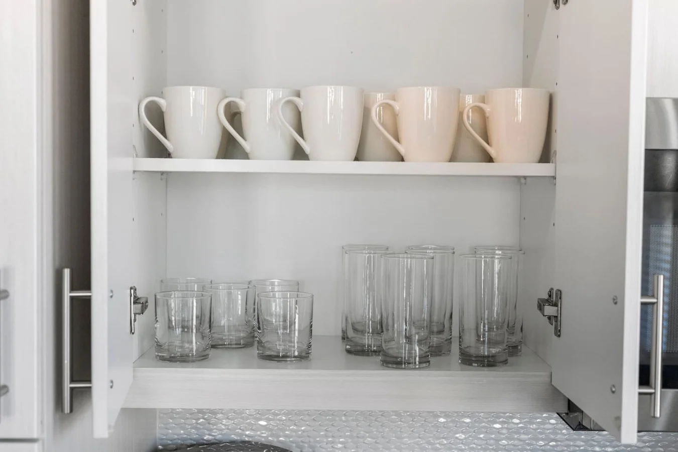 Kitchen cabinets stocked with cooking wares, glassware and silverwares, ideal for mixing up your favorite meals and drinks during your stay.