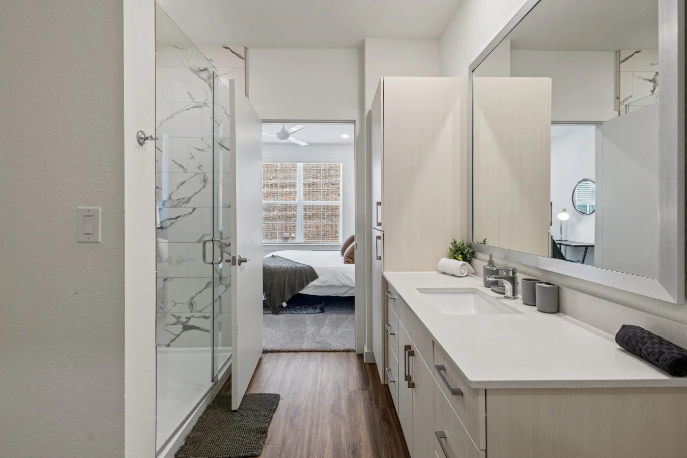 Spacious modern bathroom with a walk-in glass shower, conveniently connected to the bedroom for easy access.