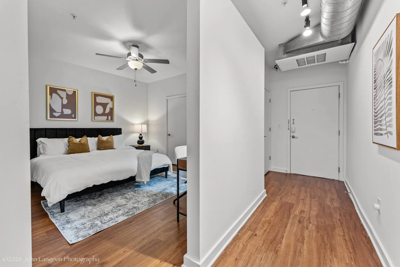 Retreat to the cozy master bedroom featuring a luxurious king-size bed with plush pillows, modern decor, blackout curtains, and a convenient workspace for all your needs.