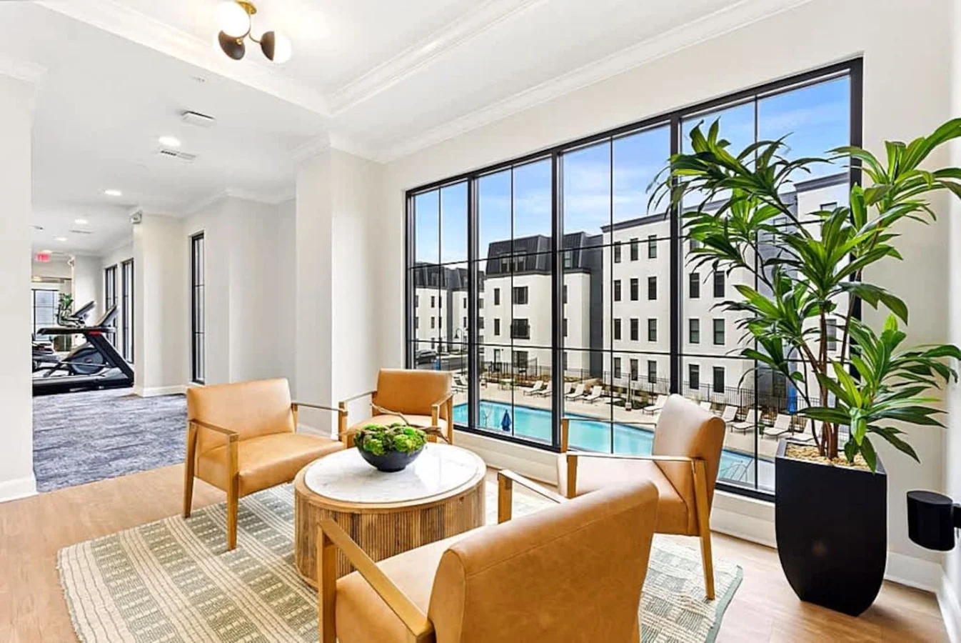 A bright indoor social space with large windows, stylish seating, and views of the community. A great spot to work, relax, or enjoy quiet moments. The modern decor adds comfort and charm to the shared amenities.