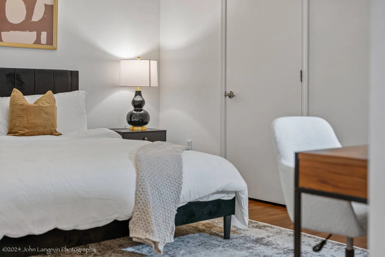 Retreat to the cozy master bedroom featuring a luxurious king-size bed with plush pillows, modern decor, blackout curtains, and a convenient workspace for all your needs.