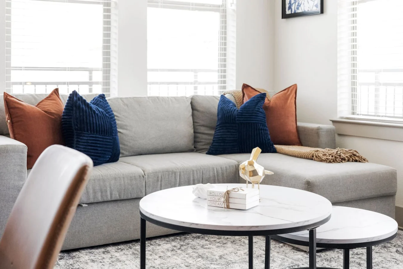 The living room’s plush seating beckons you to sink in and relax, surrounded by light and airy decor.
