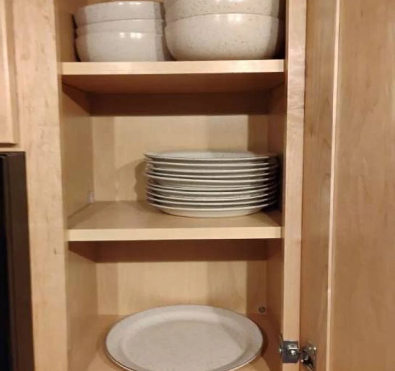 Well-stocked cabinets with plates, bowls, and cookware