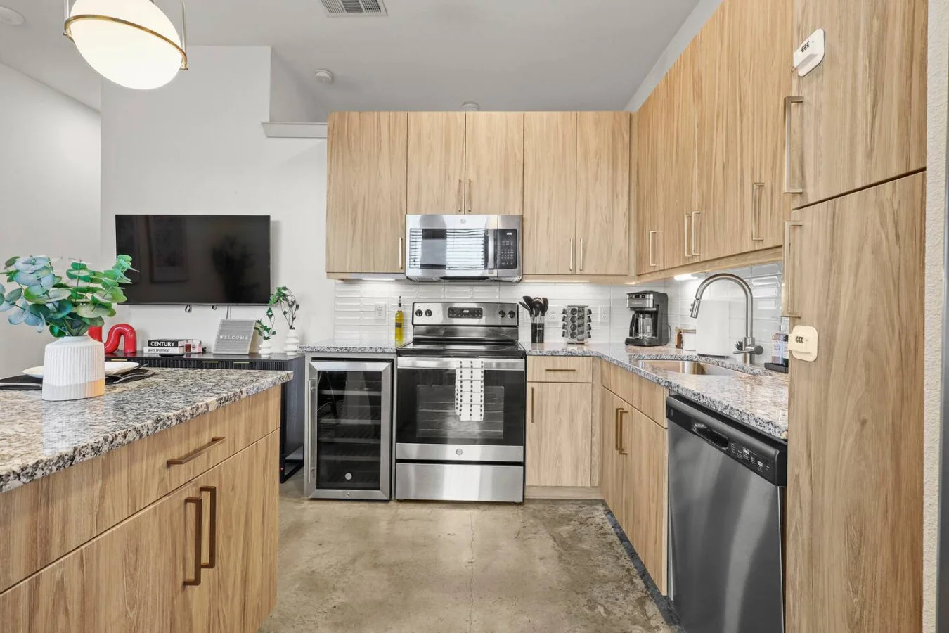 Cook with ease in this well-equipped kitchen featuring stainless steel appliances, ample cabinetry, and a stylish backsplash. Whether you're brewing coffee or preparing a gourmet meal, this space is designed for functionality and style, making every meal