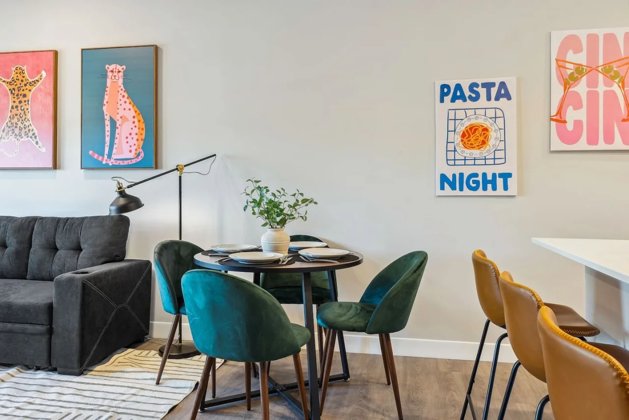 Spacious open-concept living and dining area featuring a vibrant blue sofa, modern furnishings, and a stylish entertainment setup—ideal for gatherings and relaxation.