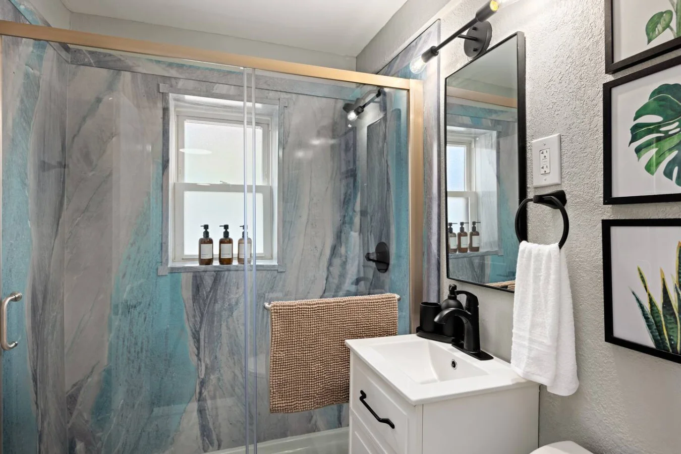This bright and welcoming bathroom invites you to freshen up in comfort. Enjoy the forest-inspired shower curtain that adds a calming touch to your routine, complemented by the cozy rug underfoot and sparkling clean fixtures.