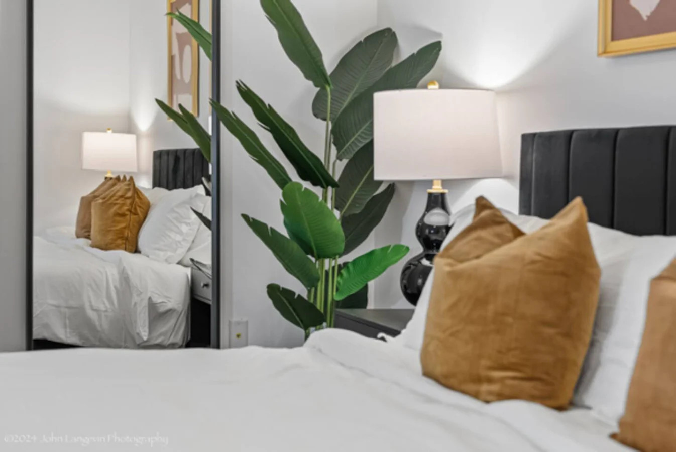 Experience serene nights with soft lighting and cozy accents in this inviting master bedroom. The bedside lamp, lush pillows, and elegant decor create a perfect retreat for relaxation.