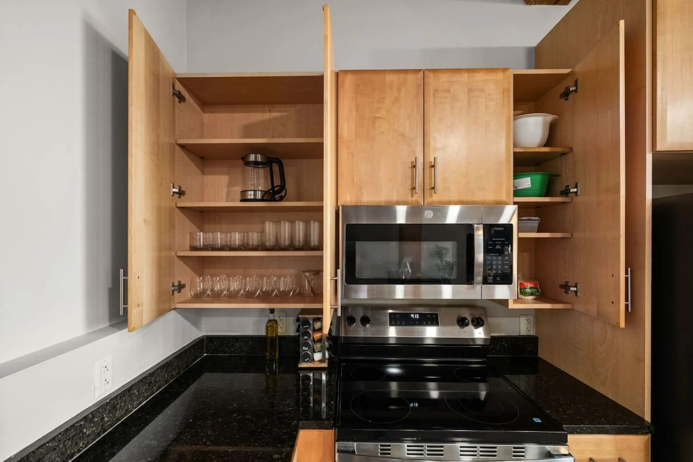 Kitchen equipped with tableware, cookware, glassware.