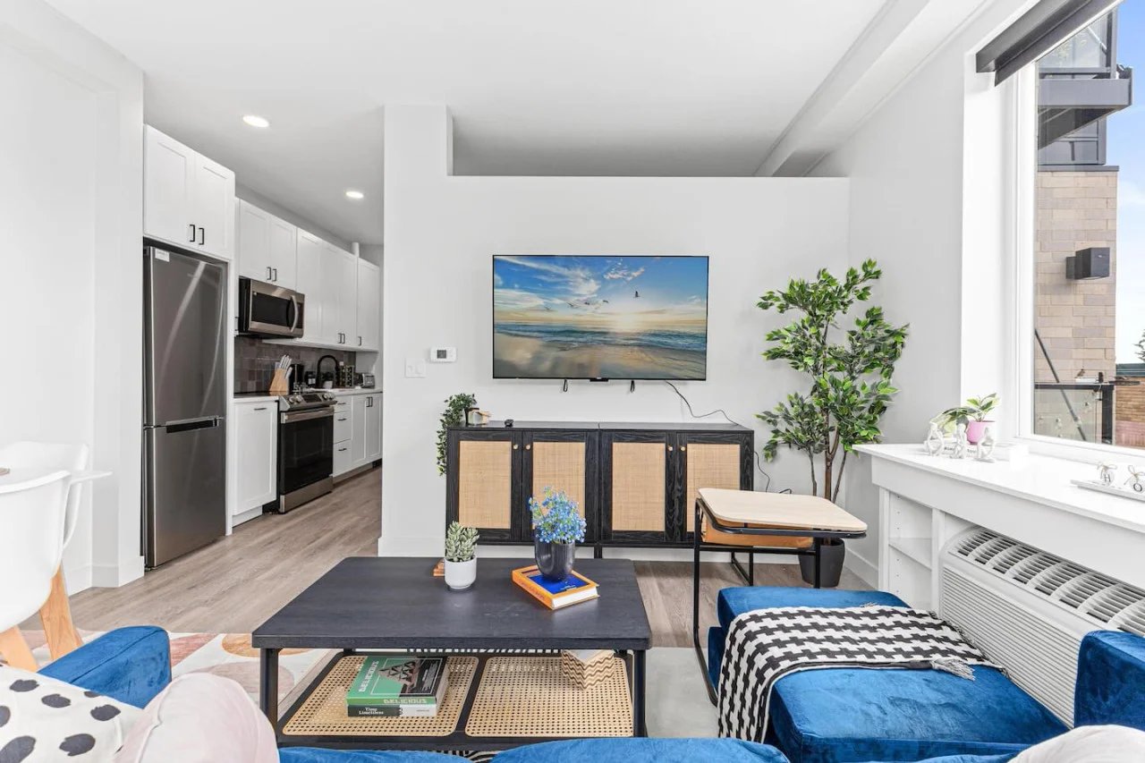 Bright and airy living room with plush seating, a large TV, and tasteful decor, creating the perfect space for relaxation and entertainment.