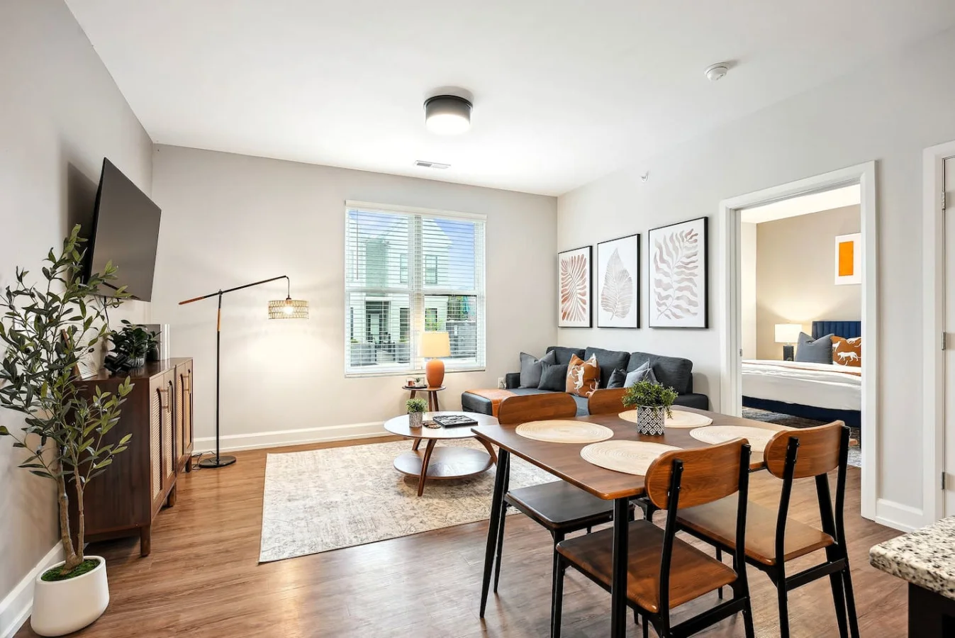 Spacious open-concept living and dining area featuring a vibrant sofa, modern furnishings, and a stylish entertainment setup—ideal for gatherings and relaxation.
