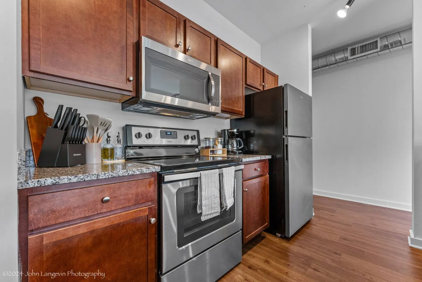 Cook with ease in this well-equipped kitchen featuring stainless steel appliances, ample cabinetry, and a stylish backsplash. Whether you're brewing coffee or preparing a gourmet meal, this space is designed for functionality and style, making every meal