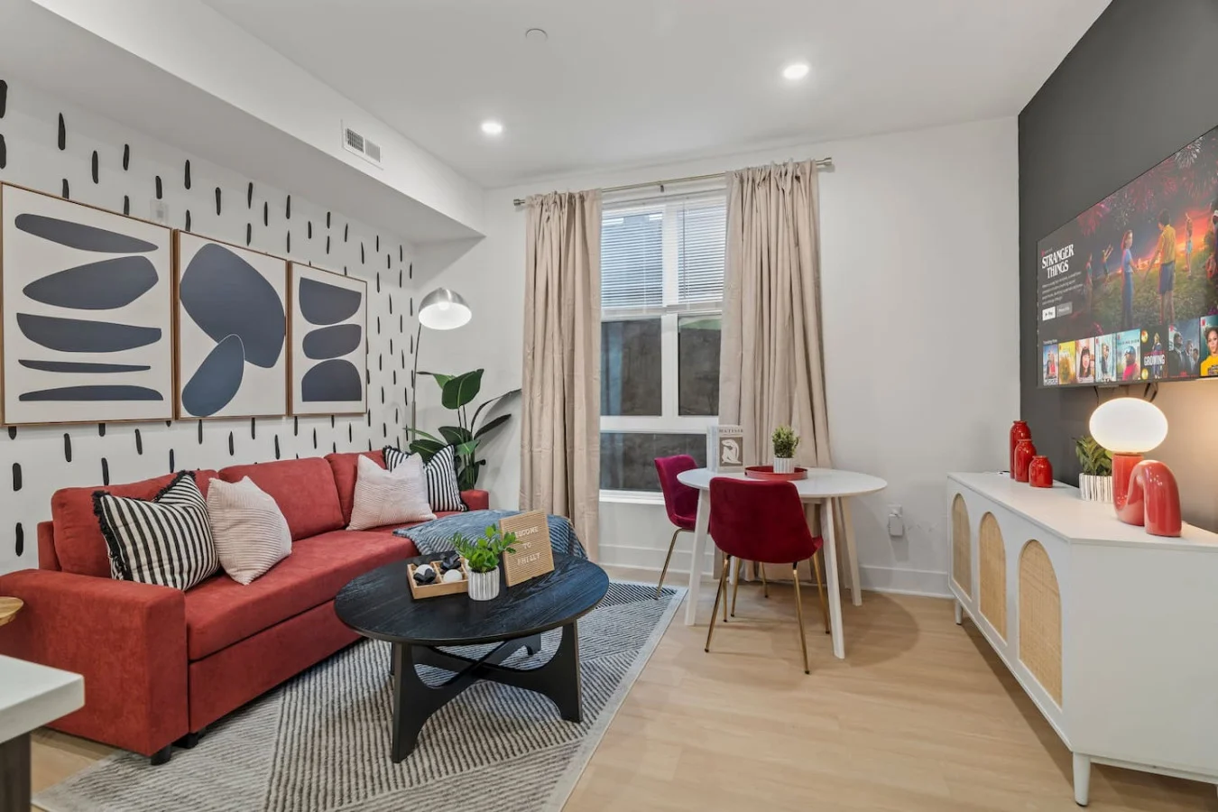 The living room’s plush seating beckons you to sink in and relax, surrounded by light and airy decor.