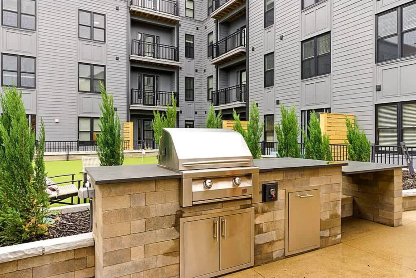 A well appointed outdoor kitchen featuring multiple stainless steel grills and prep counters. Designed for convenience and group gatherings, this shared amenity gives guests an enjoyable outdoor cooking experience.