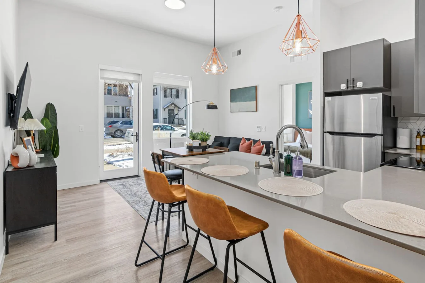 Spacious open-concept living and dining area featuring a vibrant sofa, modern furnishings, and a stylish entertainment setup—ideal for gatherings and relaxation.