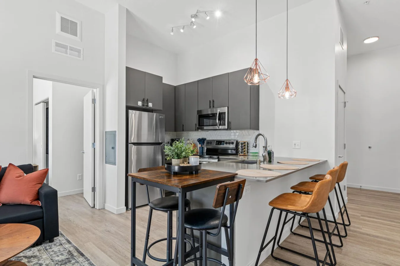 Spacious open-concept living and dining area featuring a vibrant sofa, modern furnishings, and a stylish entertainment setup—ideal for gatherings and relaxation.