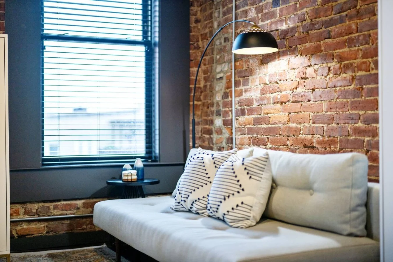 The living room’s plush seating beckons you to sink in and relax, surrounded by light and airy decor.