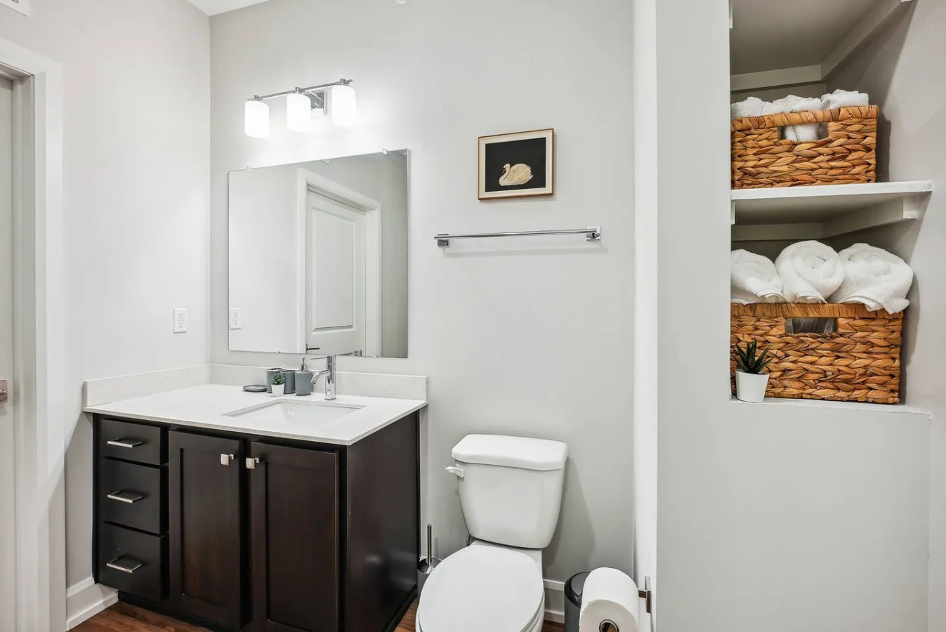 This bright and welcoming bathroom invites you to freshen up in comfort. Enjoy the forest-inspired shower curtain that adds a calming touch to your routine, complemented by the cozy rug underfoot and sparkling clean fixtures.