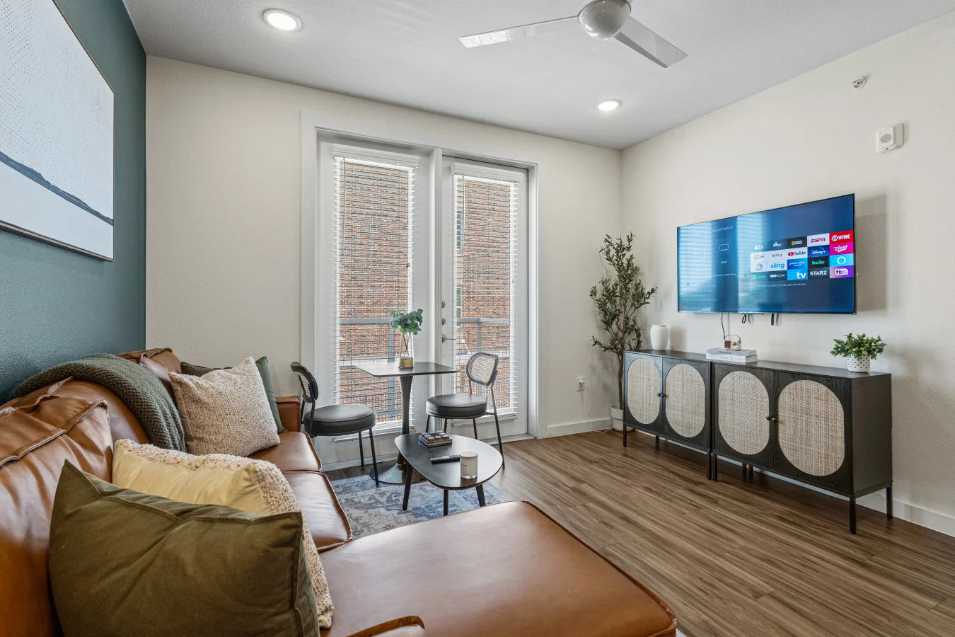 Relax in our modern living room, featuring a comfortable leather sectional and plenty of natural light.