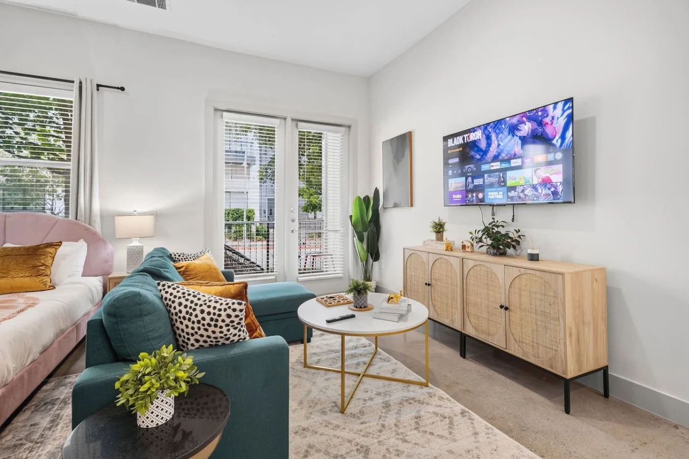 Inviting lounge area with natural light, modern entertainment setup, and warm woven wood textures.