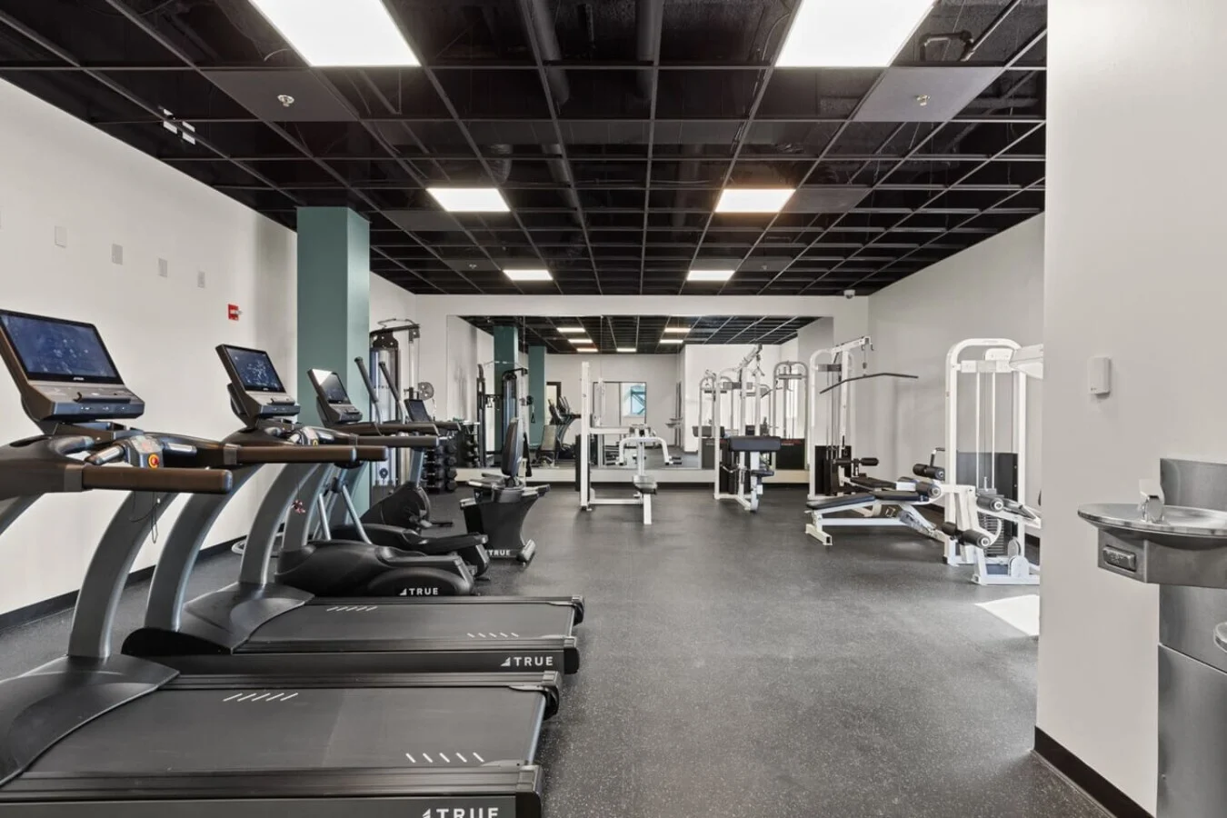 Communal gym with extensive equipment and water fountains.