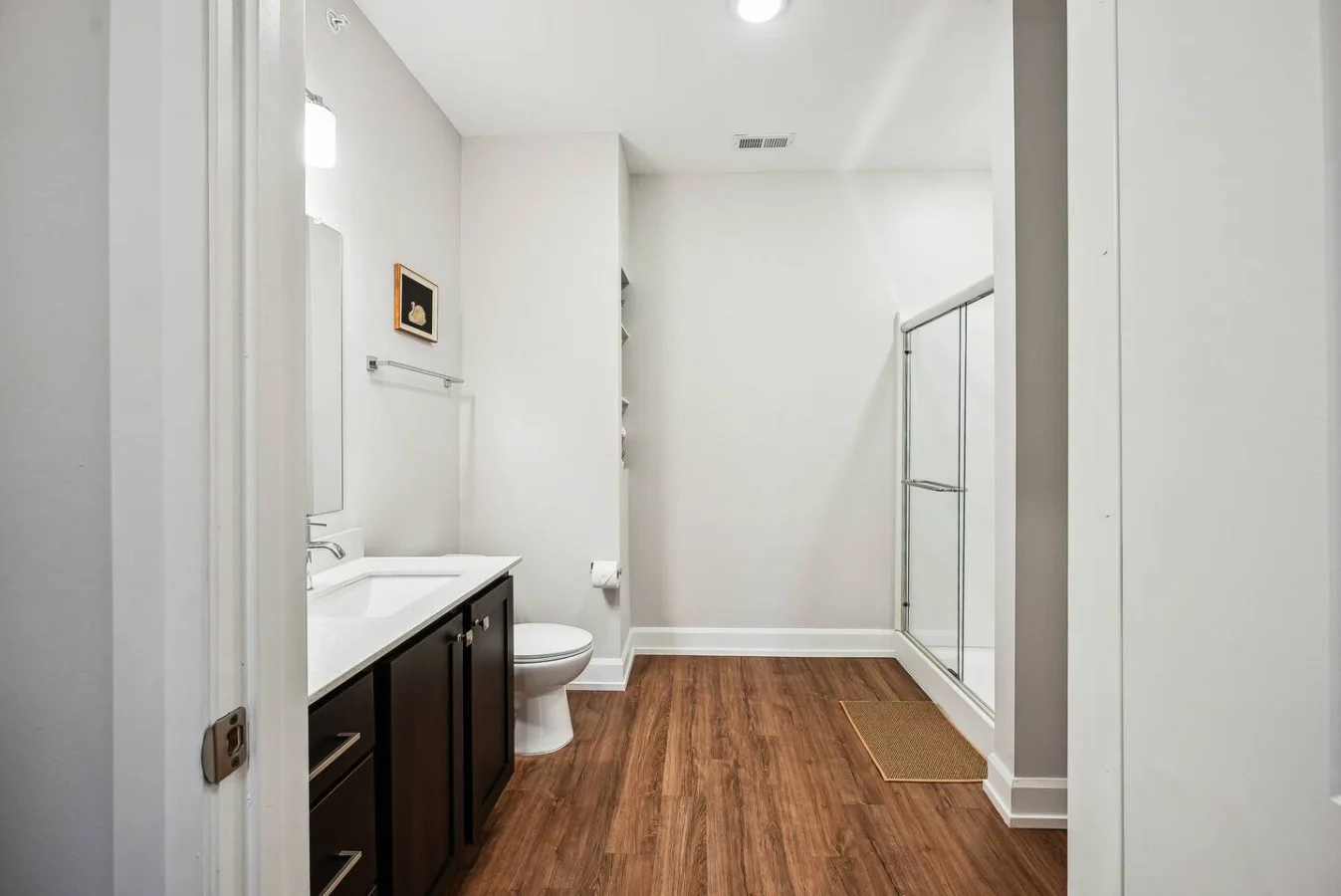This bright and welcoming bathroom invites you to freshen up in comfort. Enjoy the forest-inspired shower curtain that adds a calming touch to your routine, complemented by the cozy rug underfoot and sparkling clean fixtures.