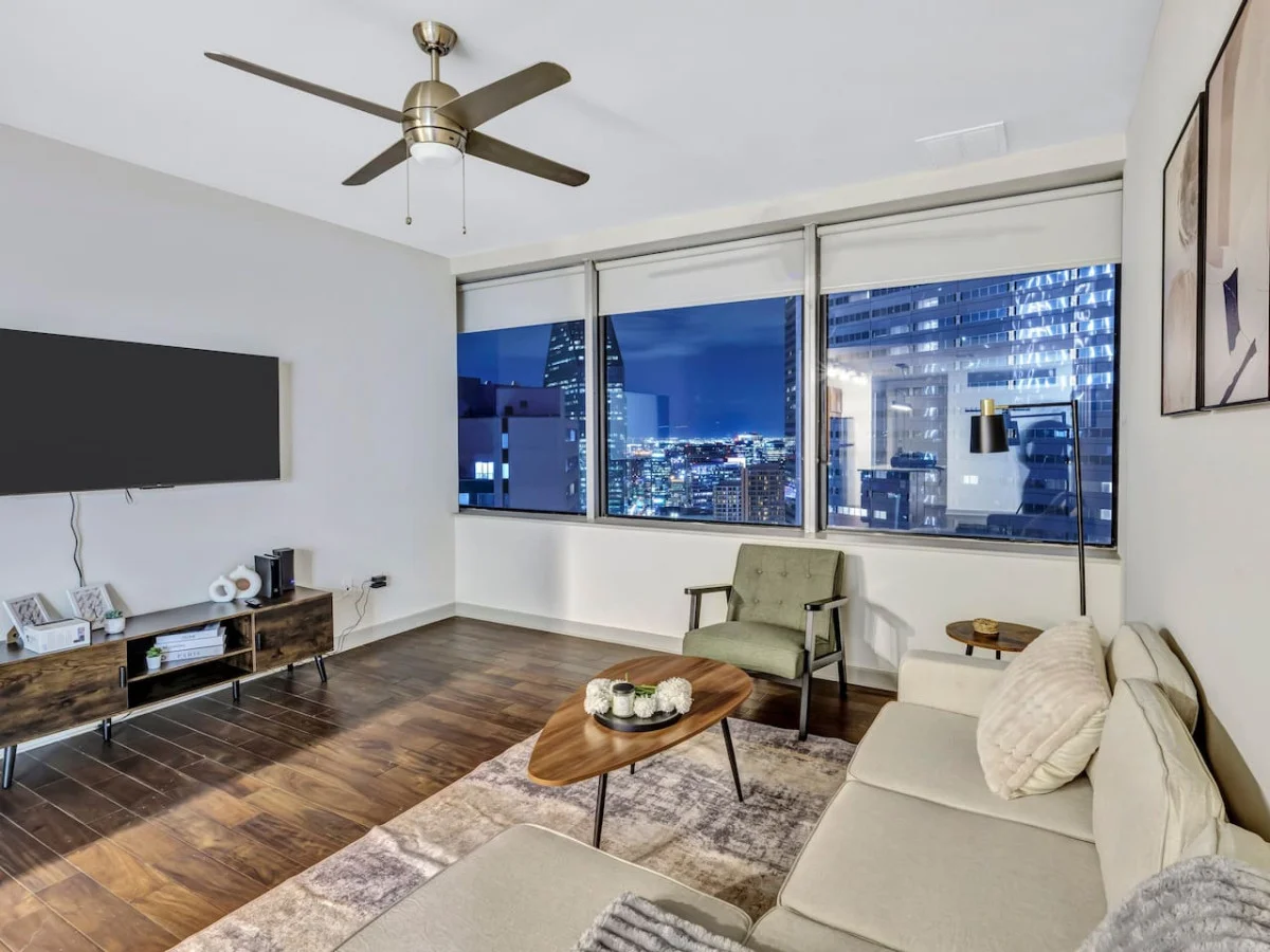 Bright and airy living room with plush seating, a large TV, and tasteful decor, creating the perfect space for relaxation and entertainment.