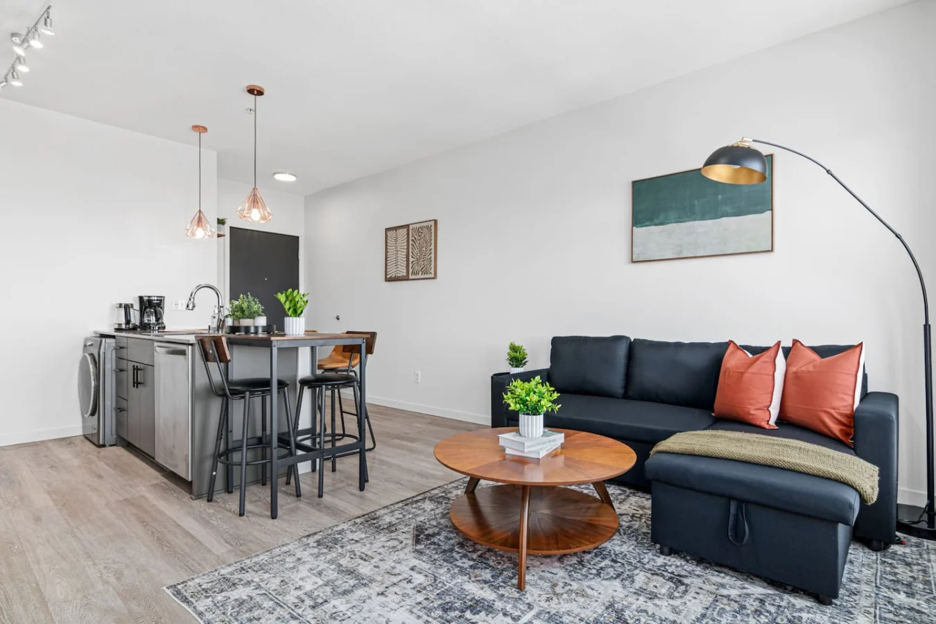 Spacious open-concept living and dining area featuring a vibrant sofa, modern furnishings, and a stylish entertainment setup—ideal for gatherings and relaxation.