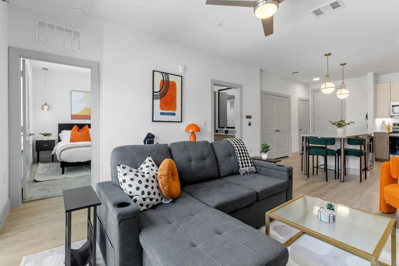 The living room’s plush seating beckons you to sink in and relax, surrounded by light and airy decor.