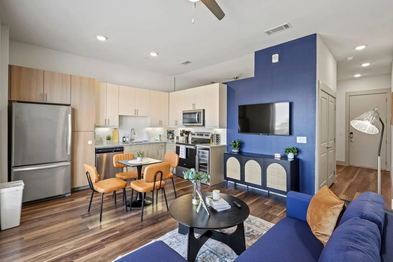 Spacious open-concept living and dining area featuring a vibrant sofa, modern furnishings, and a stylish entertainment setup—ideal for gatherings and relaxation.
