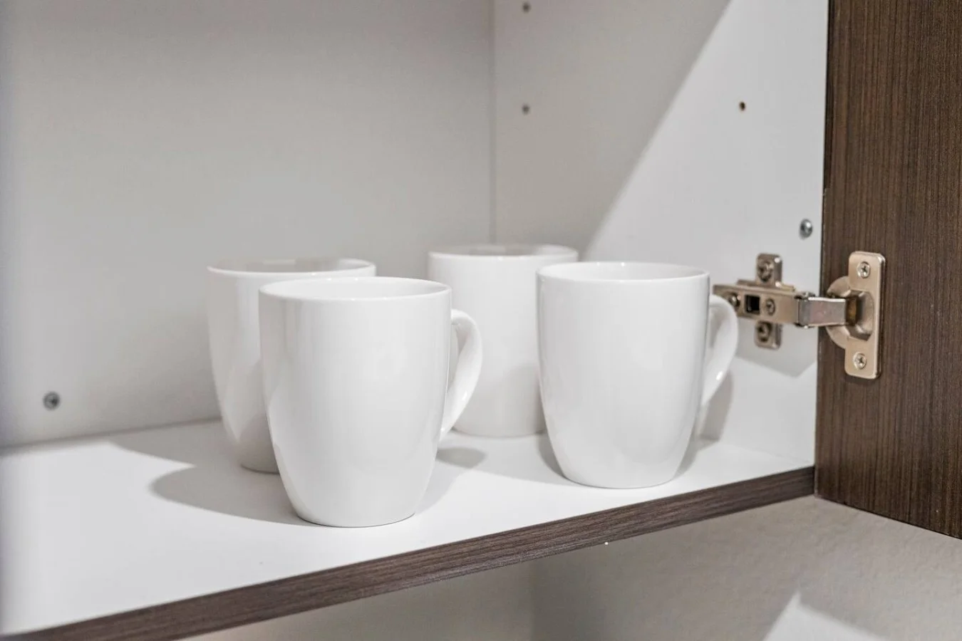 Four clean mugs walk into a cabinet... and wait for the caffeine rush.