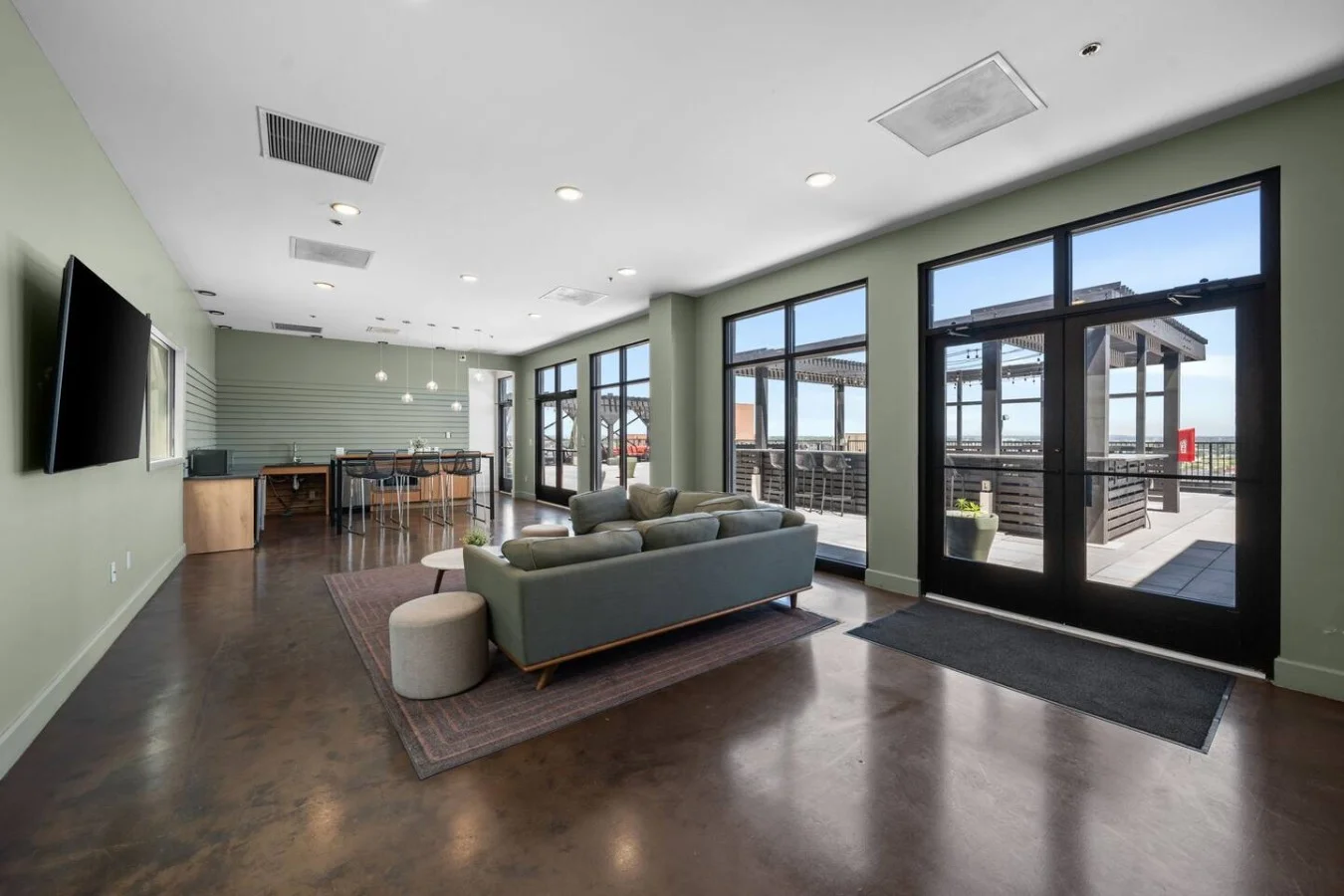 City views from the rooftop lounge with TV, seating and kitchen