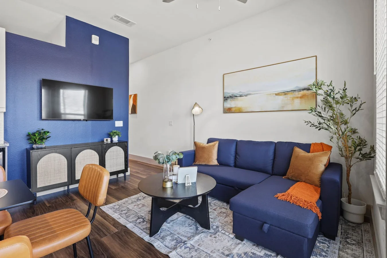The living room’s plush seating beckons you to sink in and relax, surrounded by light and airy decor.