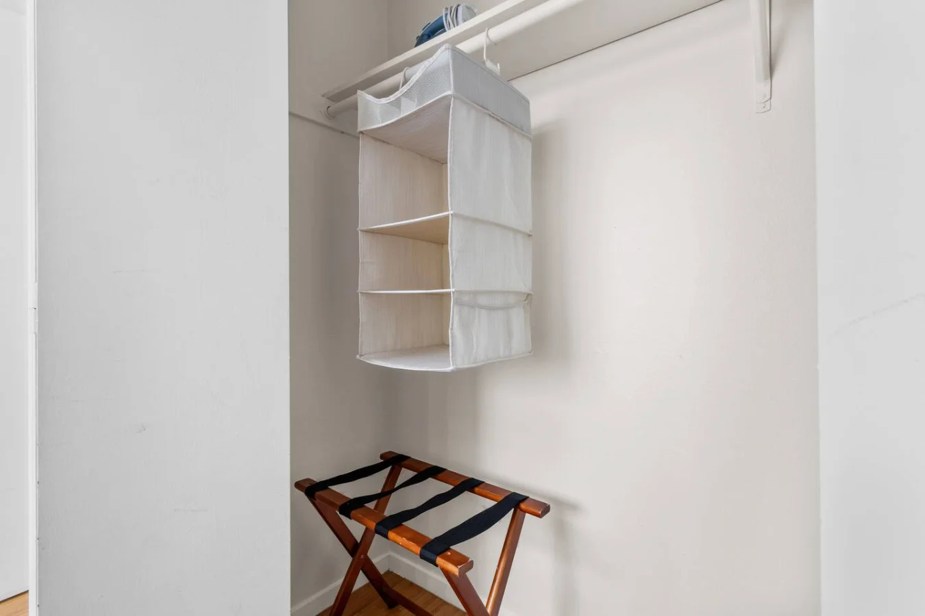 Open closet space with shelving and luggage rack
