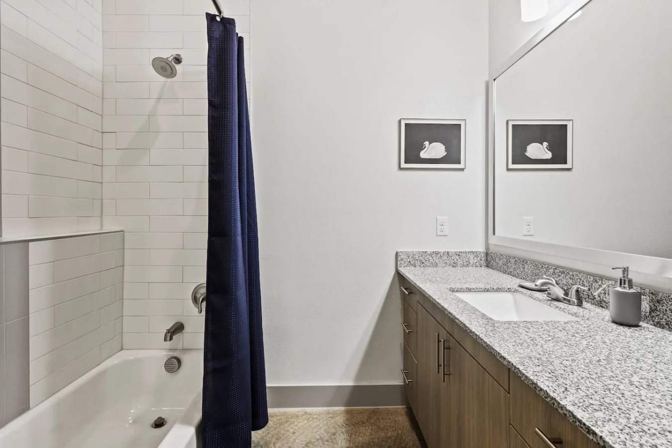 This bright and welcoming bathroom invites you to freshen up in comfort. Enjoy the forest-inspired shower curtain that adds a calming touch to your routine, complemented by the cozy rug underfoot and sparkling clean fixtures.