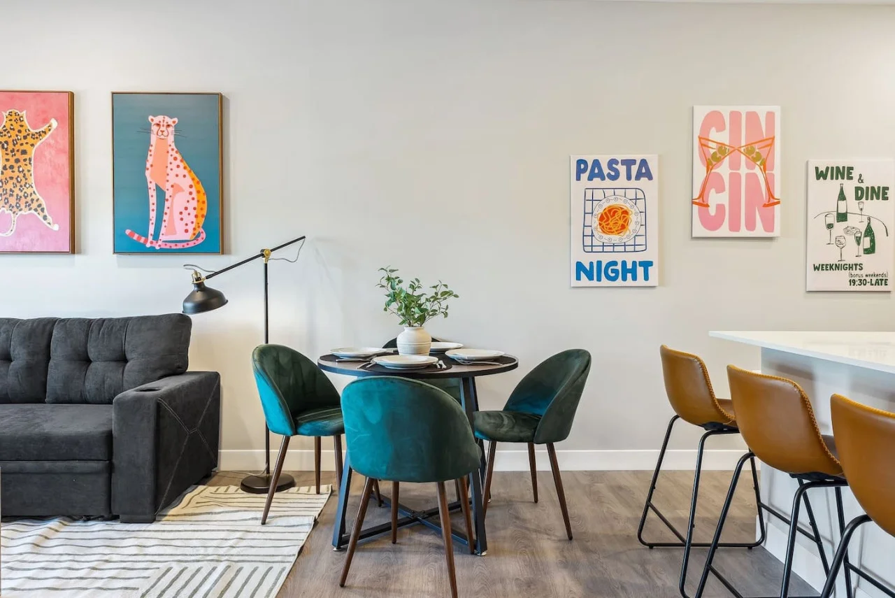 Spacious open-concept living and dining area featuring a vibrant blue sofa, modern furnishings, and a stylish entertainment setup—ideal for gatherings and relaxation.
