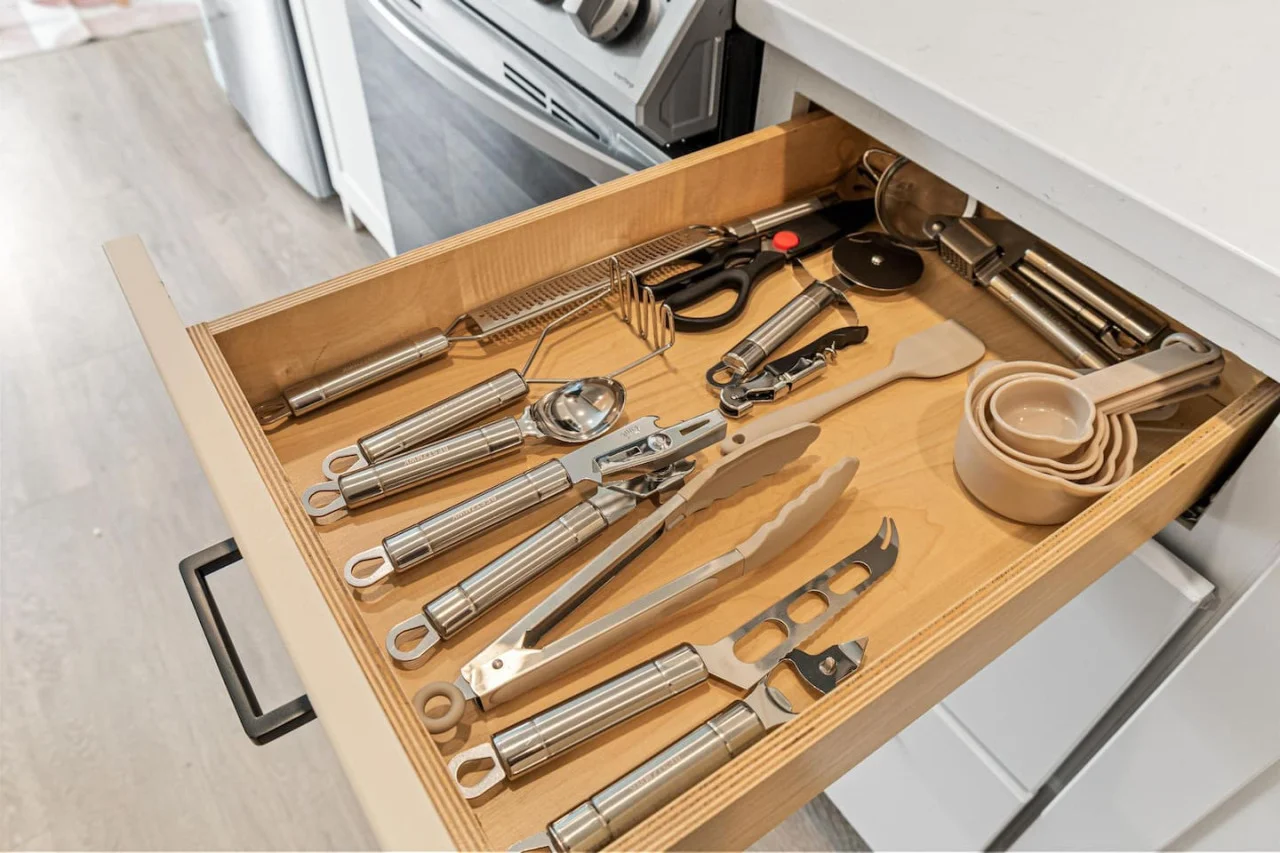 Kitchen Draw full of essential cooking utensils - Measuring cups - Scissors - Bottle opener - Can opener - Pizza cutter and more.